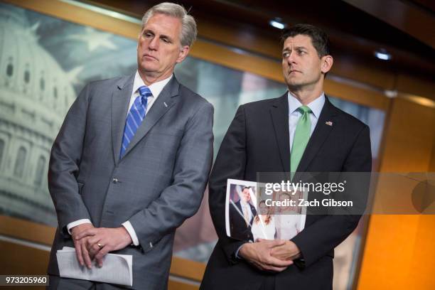 House Majority Leader Kevin McCarthy, , left, and House Speaker Paul Ryan, , holding a photograph of himself with people in his district who have...