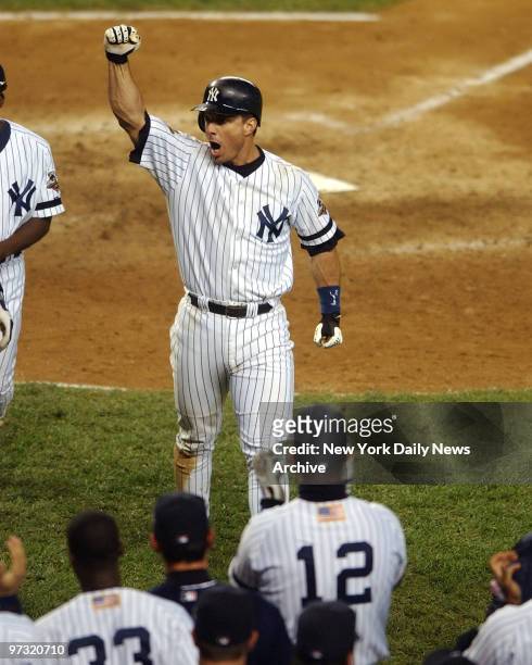 New York Yankees' Tino Martinez raises his fist in celebration after his two-run homer in the ninth inning tied Game 4 of the World Series against...