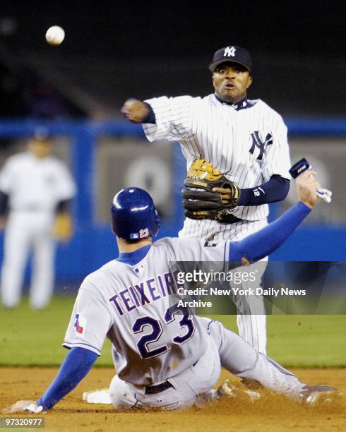 New York Yankees' Tony Womack throws to first as Texas Rangers' Mark Teixeira is out at second on a fielder's choice in the third inning at Yankee...