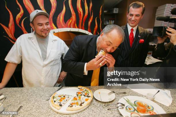 Ulises "Miguel" Virafuentes and Nino's Bellissima Pizza restaurant owner Nino Selimaj watch as Bo Dietl tries a slice of their $1,000 luxury pizza...