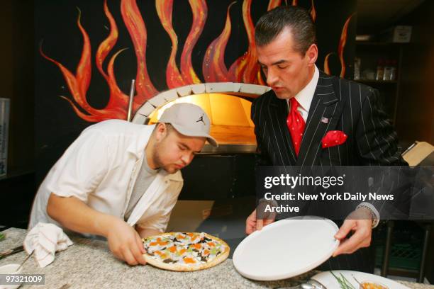 Ulises "Miguel" Virafuentes gingerly helps plate a $1,000 luxury pizza pie with Nino's Bellissima Pizza restaurant owner Nino Selimaj. The pricey...