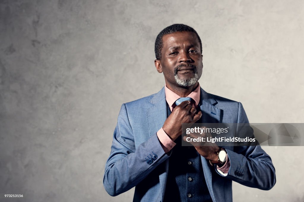 Middle aged african american man fixing tie