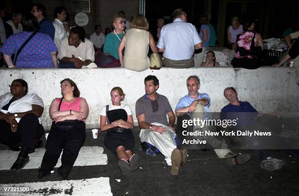 Stranded commuters sit outside Grand Central Terminal at 42nd St. After a massive power failure caused the largest power outage in the nation's...