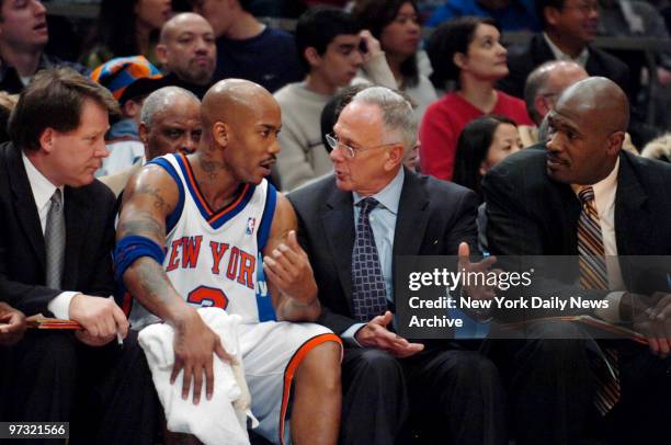 New York Knicks' point guard Stephon Marbury talks with head coach Larry Brown on the bench as assistant coach Herb Williams looks on during the...