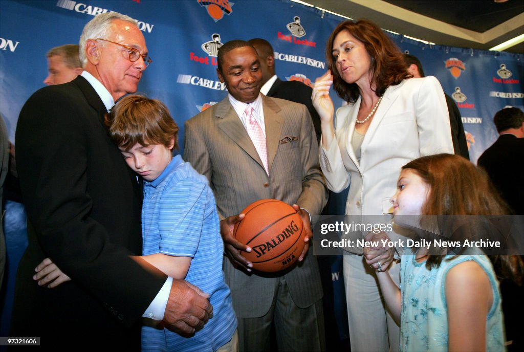 New York Knicks' president Isiah Thomas (center) smiles as L