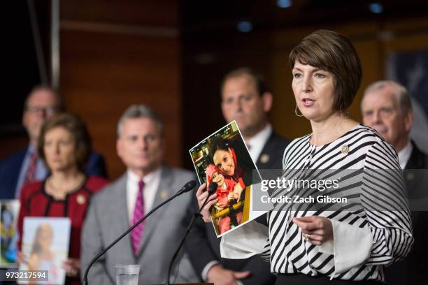 Rep. Cathy McMorris Rodgers holds up a photograph of people in her district who have been affected by the opioid epidemic during a news conference...