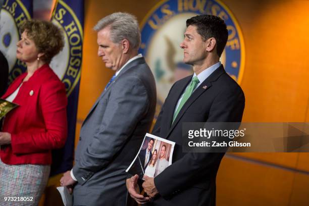 House Majority Leader Kevin McCarthy, , left, and House Speaker Paul Ryan, , holding a photograph of himself with people in his district who have...