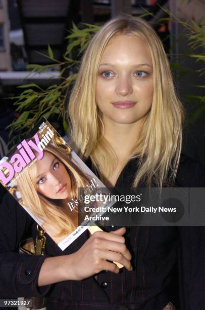 Supermodel Gemma Ward holds a copy of the cover of the premiere issue of Daily Mini with her picture on it during a launch party for the new fashion...