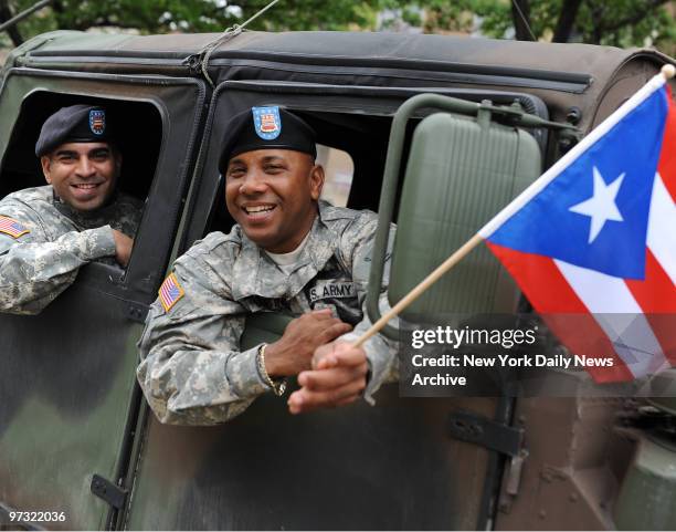 Veloz and Martinez of the Army wave the Puerto Rican flag during the Day Parade on the Grand Concourse