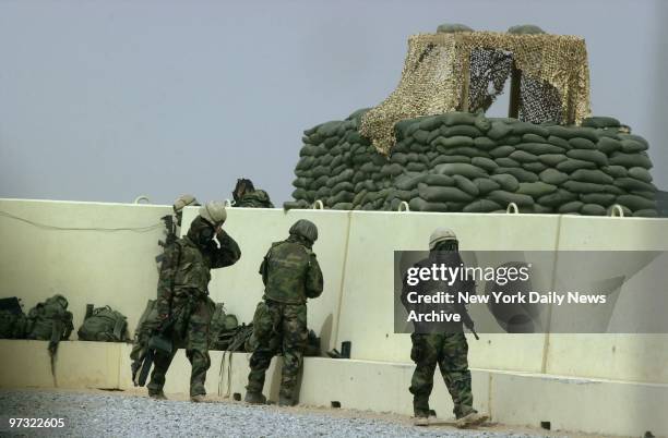 Guards at an air base near the Iraqi border emerge from a bunker after an air raid. Troops are on alert and wearing their chemical suits because of a...