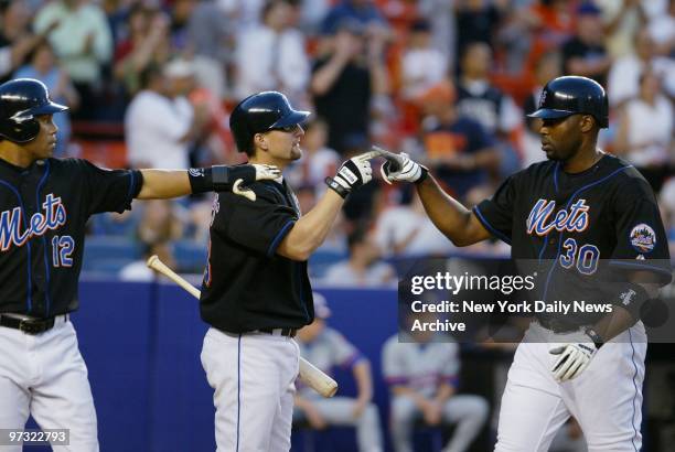 New York Mets' Cliff Floyd is congratulated at the plate by Jason Phillips after he and Roberto Alomar scored on a double in the third inning against...