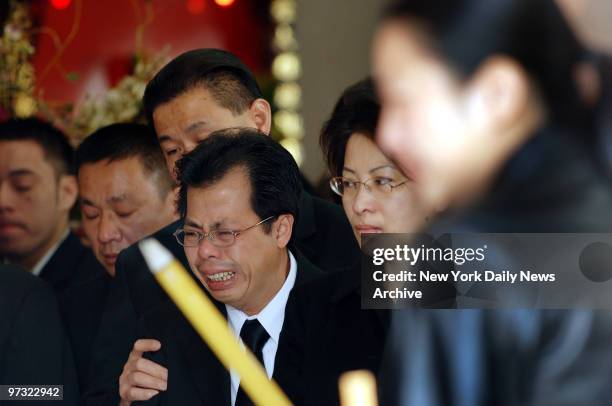 Kam and Karen Lao grieve during a traditional Buddhist funeral service for their daughter, 14-year-old April Lao, at the Chun Fook Funeral Home in...