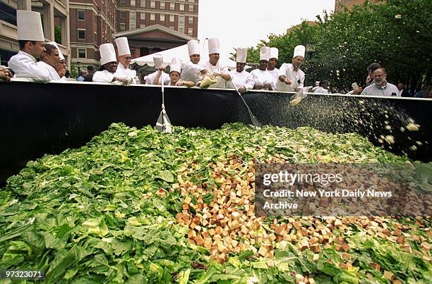 Students from New York City Technical College toss parmesan cheese into a massive bed of lettuce in a bid to create the world's largest Caesar salad...