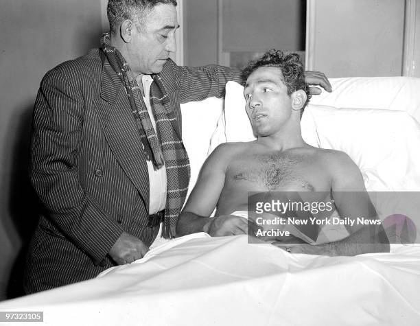 Suffering injuries to his left ankle, world featherweight boxing champion Willie Pep is comforted by his dad, Salvatore Papaleo, at Millville, N.J....