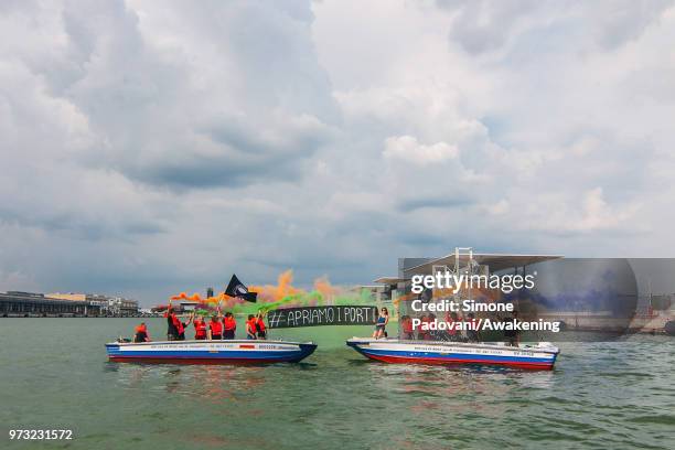 Protesters shows banners against the Italian government's decision to block ports to a German NGO ship with 629 migrants on board on June 13, 2018 in...