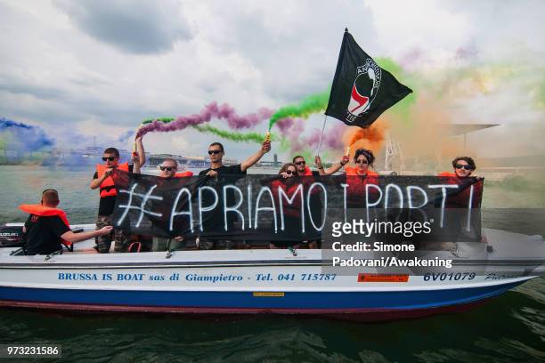 Protesters shows banners against the Italian government's decision to block ports to a German NGO ship with 629 migrants on board on June 13, 2018 in...