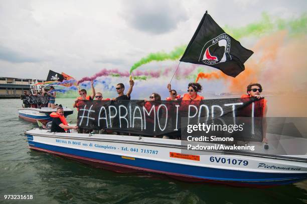 Protesters shows banners against the Italian government's decision to block ports to a German NGO ship with 629 migrants on board on June 13, 2018 in...