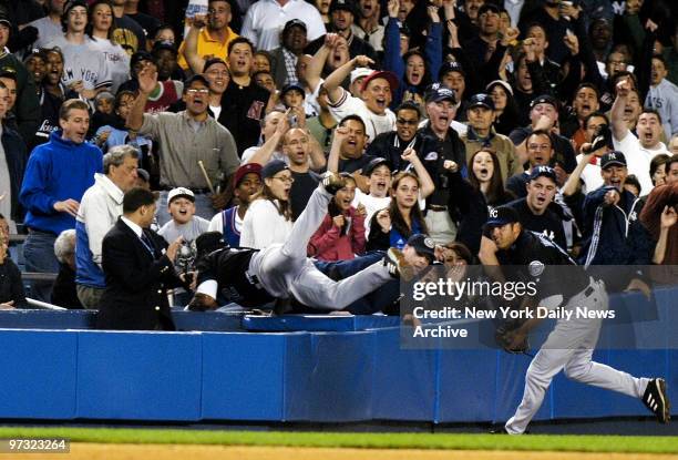 Kansas City Royals' Desi Relaford crashes into the stands while trying to field a fly ball from New York Yankees' Bernie Williams during the eighth...