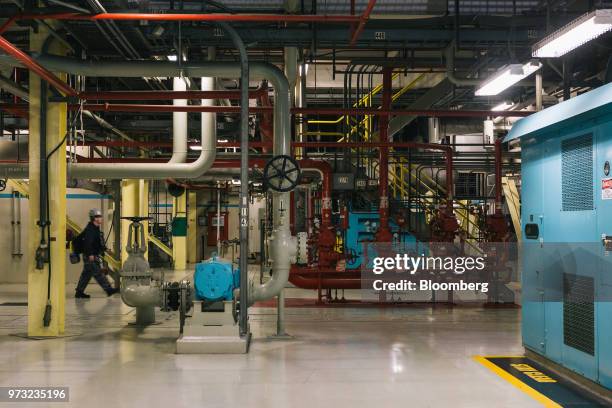 Worker walks through the lower level turbine room at the Exelon Corp. Three Mile Island nuclear power plant in Middletown, Pennsylvania, U.S., on...