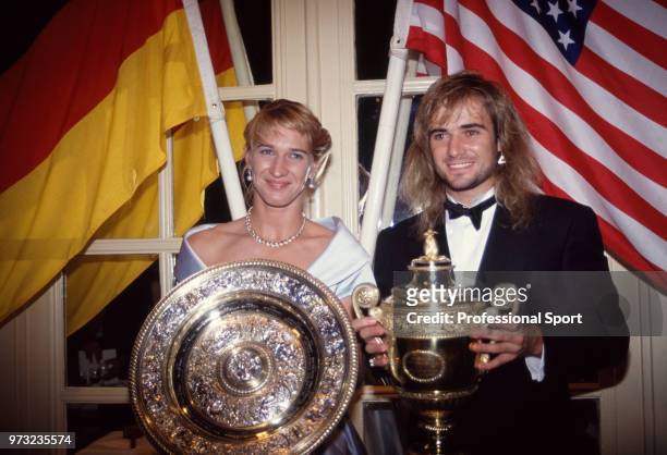 Singles champions Steffi Graf of Germany and Andre Agassi of the USA pose with their trophies at the Wimbledon Champions' Dinner after the Wimbledon...