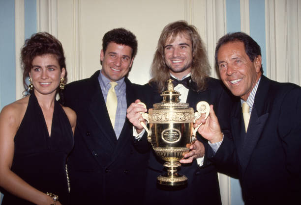 Men's singles champion Andre Agassi of the USA poses with his coach Nick Bollettieri , his girlfriend Wendi Stewart and brother Philip at the...