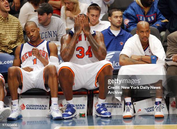 New York Knicks' Steve Francis, Eddy Curry and Stephon Marbury don't look very pleased as they sit on the bench in the second half of a game against...
