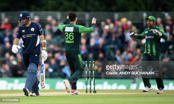 Pakistan's Usman Khan celebrates with Pakistan's Sarfraz Ahmed after taking the wicket of Scotland's captain Kyle Coetzer for one run during the...