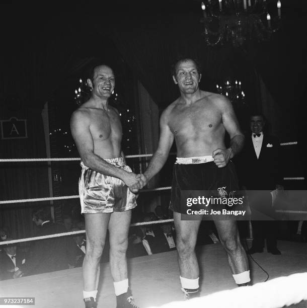 English heavyweight boxer Henry Cooper shakes hands with his identical twin George Cooper after a friendly match at the Cafe Royal, London, UK, 30th...