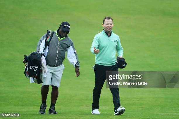 Branden Grace of South Africa walks with his caddie Zacharia Rasego during a practice round prior to the 2018 U.S. Open at Shinnecock Hills Golf Club...