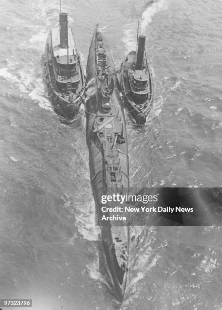 Submarine S-51 is towed through East River on the way to the Brooklyn Navy Yard. The vessel sank off Block Island after being rammed by the steamship...