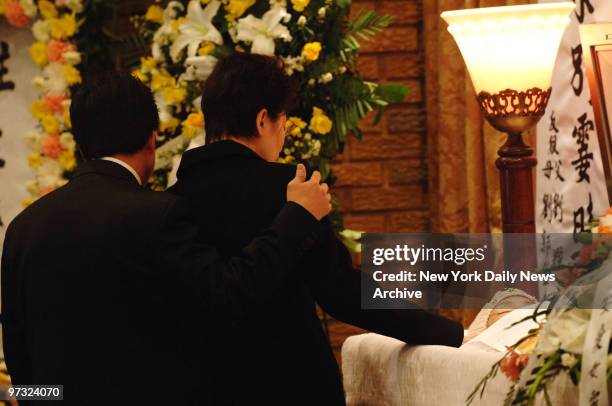 Karen Lao touches April Lao's face as she and husband Kam say their final good-byes to their daughter at her coffin prior to a traditional Buddhist...