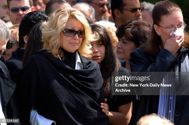 Karen Vitale, with daughters Dawn Marie, Stefanie and Michelle, cries as the coffin of her husband, retired Port Authority officer Steven Vitale, is...