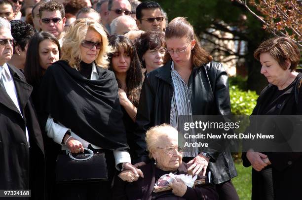 Karen Vitale, with daughters Dawn Marie, Stefanie and Michelle, holds hands with her mother-in-law, Antoinette Vitale, as the coffin of her husband,...