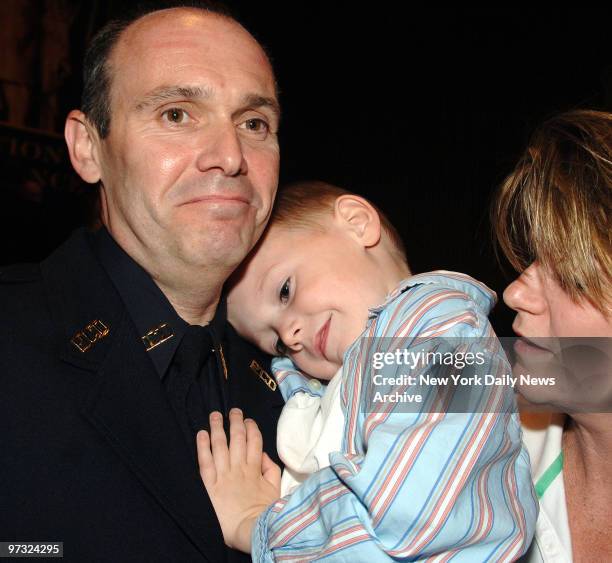 Newly-promoted Detective First Grade William Courtney beams as he's joined by wife Corinne and son Jack after NYPD promotion ceremonies at 1 Police...