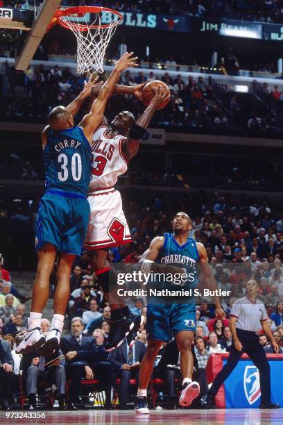 Michael Jordan of the Chicago Bulls dunks on Dell Curry of the Indiana Pacers during a game played on May 3, 1998 at the United Center in Chicago,...