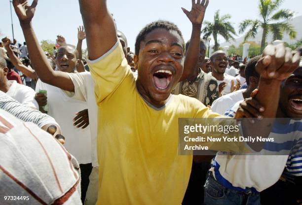 Haitians sing and dance in front of the National Palace to celebrate the arrival of the rebel army in Port-au-Prince on the day after former...