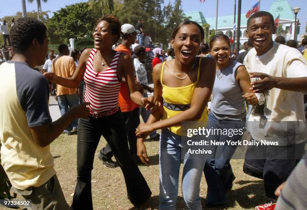 Haitians sing and dance in front of the National Palace to celebrate the arrival of the rebel army in Port-au-Prince on the day after former...