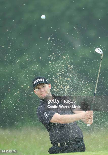 Branden Grace of South Africa plays a bunker shot on the second hole during a practice round prior to the 2018 U.S. Open at Shinnecock Hills Golf...