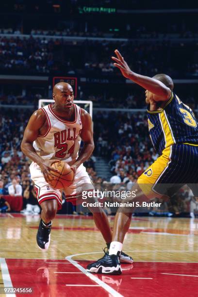 Scott Burrell of the Chicago Bulls drives as Antonio Davis of the Indiana Pacers defends during a game played on May 27, 1998 at the United Center in...