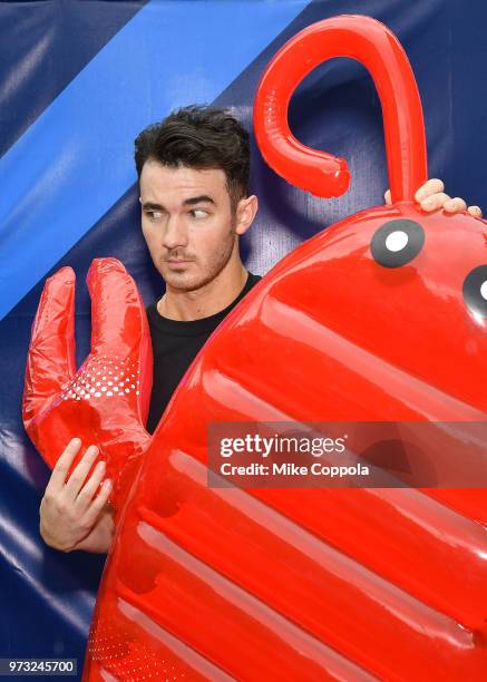 Kevin Jonas poses for a picture with an inflatable lobster as he celebrates Father's Day with Marshalls at Flatiron Plaza on June 13, 2018 in New...