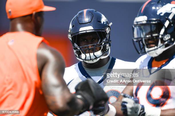 Denver Broncos linebacker Von Miller listens to former linebacker Demarcus Ware as he instructs linebackers during the team's mandatory minicamp on...
