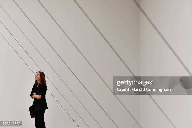 Visitor looks at the artwork of Fred Sandback "Untitled" during the press preview for Art Basel at Basel Messe on June 13, 2018 in Basel,...