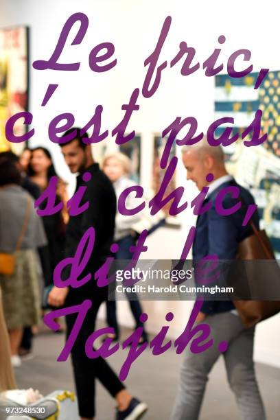 Visitors look at the artwork of Slavs and Tatars "Nations 5" during the press preview for Art Basel at Basel Messe on June 13, 2018 in Basel,...