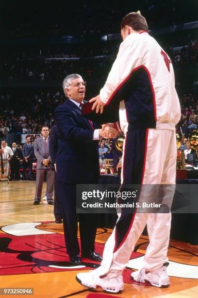 Commissioner David Stern presents Luc Longley of the Chicago Bulls with a championship ring during a game played on November 1, 1997 at the First...