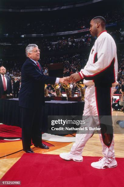 Commissioner David Stern presents Jason Caffey of the Chicago Bulls with a championship ring during a game played on November 1, 1997 at the First...