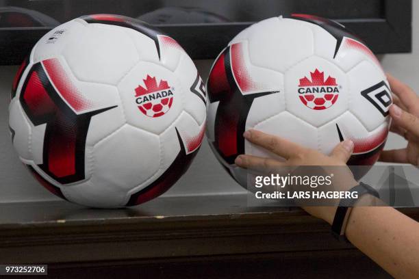 An employee looks at balls at Soccer Canada Headquarters in Ottawa, Ontario on June 13 as Canada will co-host the 2026 World Cup with Mexico and the...