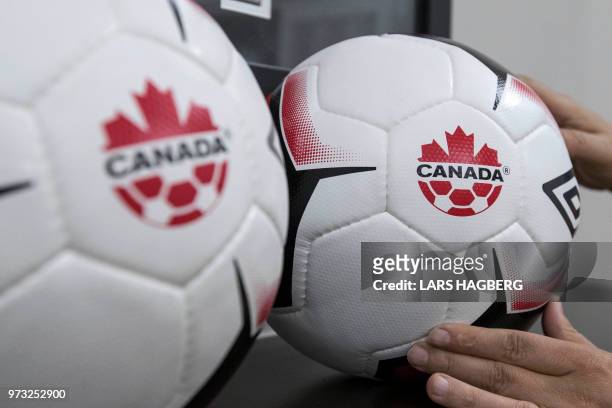 An employee adjusts balls at Soccer Canada Headquarters in Ottawa, Ontario on June 13 as Canada will co-host the 2026 World Cup with Mexico and the...