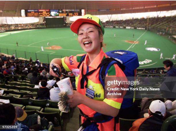 Vendor Mariko Toko dispenses beer from a minikeg in a backpack at game between the New York Mets and the Seibu Lions at the Seibu Dome.The Mets, who...