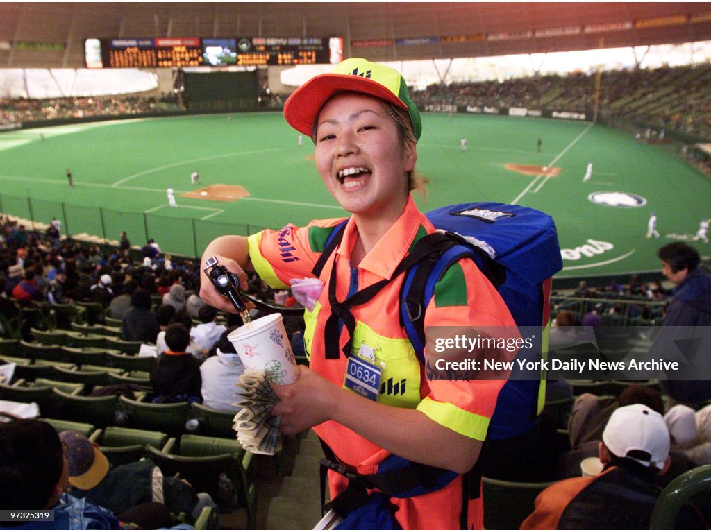 Vendor Mariko Toko, 17, dispenses beer from a minikeg in a b