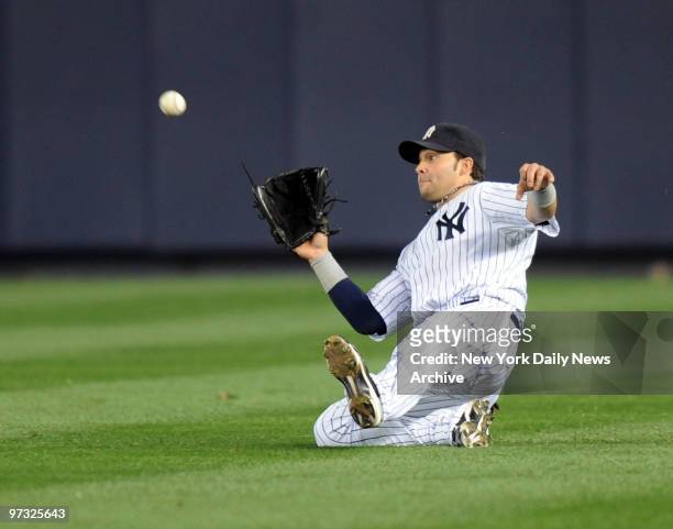 Nick Swisher makes a sliding catch in the 9th inning of game 2 of the American League Division Series between the New York Yankees and Minnesota...